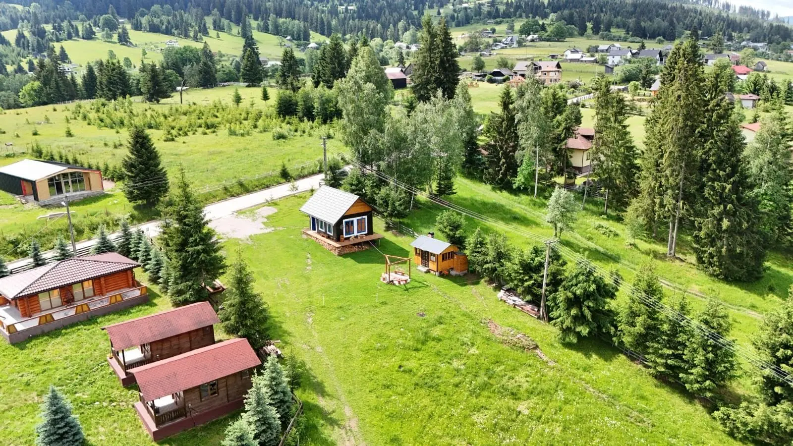 Cabana Vatra Plaiului văzută de sus, într-o vale verde din Șaru Dornei